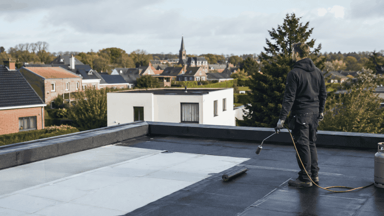 Couvreur professionnel sur une toiture plate en Belgique avec membrane d’étanchéité